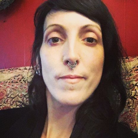 Tarot & astrology counselor, Esme Midnight sitting in her residence in Portland, Oregon.