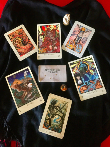 Tarot cards of Death, The Devil & The Tower surround a card that says "Get your ass to Mars